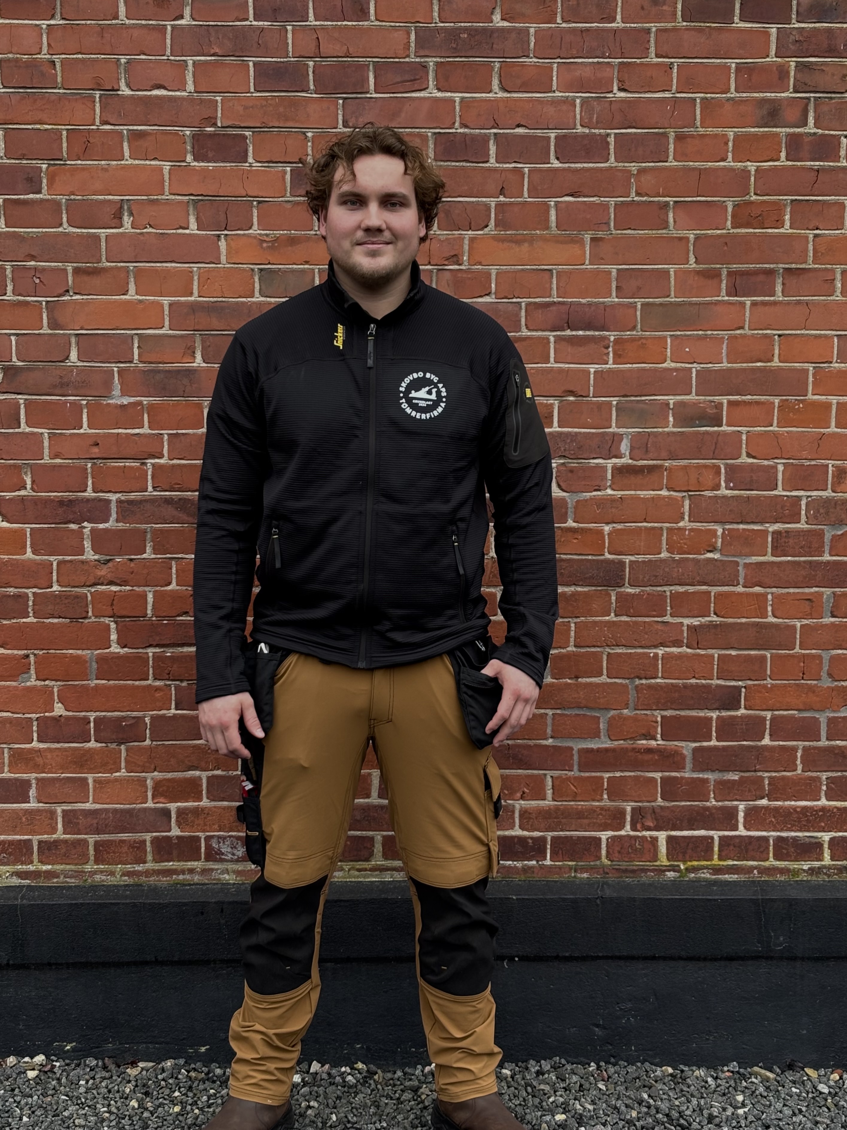 Skovbo Bygs logo på brystet af Williams arbejdstøj